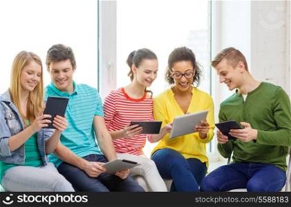 education and technology concept - smiling students with tablet pc computer at school