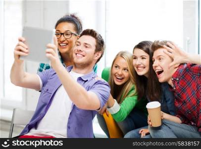 education and technology - group of students taking selfie with tablet pc at school