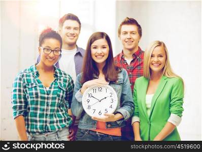 education and time concept - group of students at school with clock. group of students at school with clock