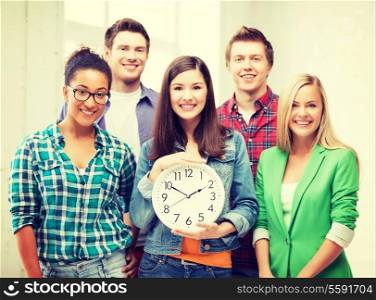 education and time concept - group of students at school with clock