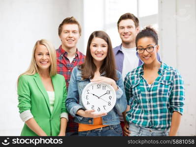 education and time concept - group of students at school with clock