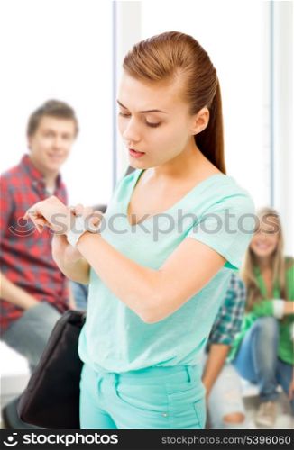 education and time management concept - student girl looking at wristwatch