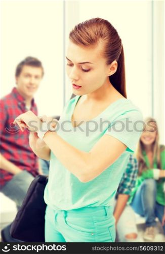 education and time management concept - student girl looking at wristwatch