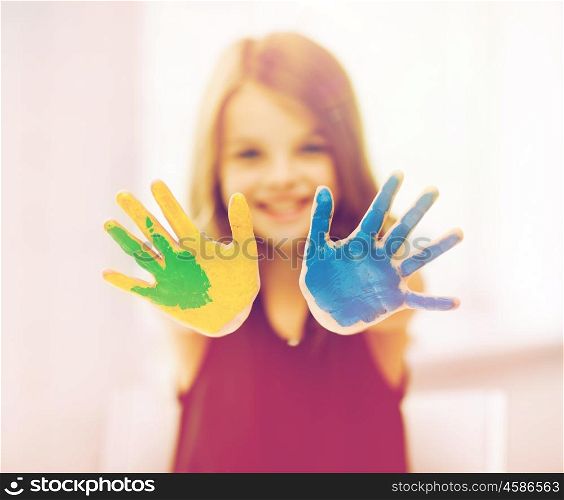 education, art, people, childhood and drawing concept - little happy student girl showing painted hands