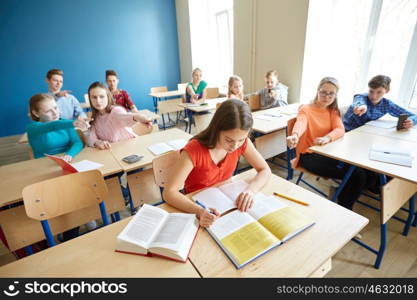 education, bullying, conflict, social relations and people concept - students teasing and judging girl classmate behind her back at school