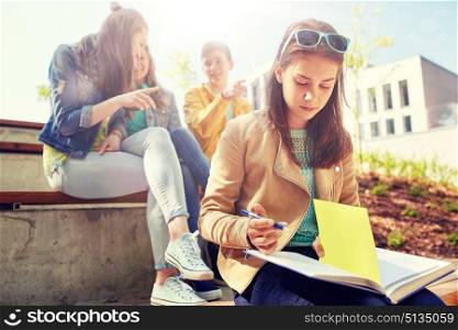 education, bullying, high school, social relations and people concept - unhappy student girl with book suffering of classmates mockery. student girl suffering of classmates mockery. student girl suffering of classmates mockery