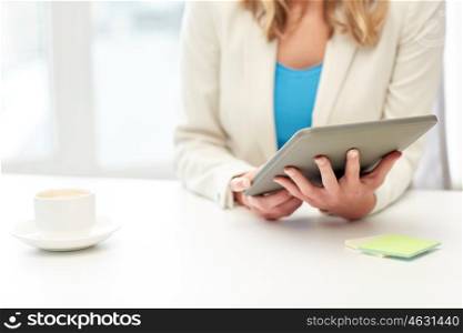 education, business and technology concept - close up of businesswoman or student with tablet pc computer and coffee cup at office table