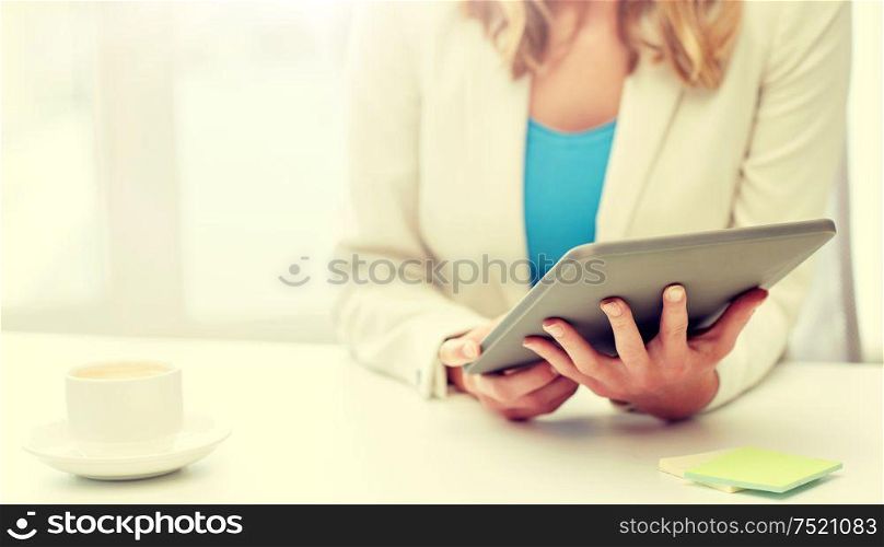 education, business and technology concept - close up of businesswoman or student with tablet pc computer and coffee cup at office table. close up of businesswoman with tablet pc