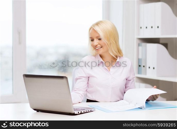 education, business and technology concept - smiling businesswoman or student with laptop computer and documents in office