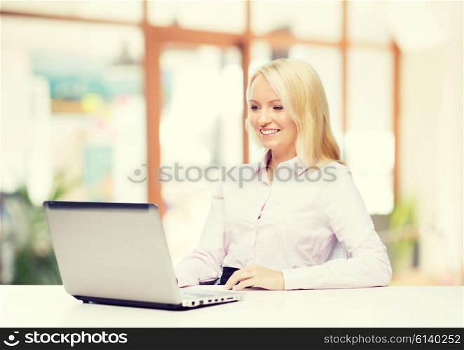education, business and technology concept - smiling businesswoman or student with laptop computer over office room background