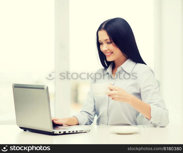 education, business and technology concept - smiling businesswoman or student with laptop computer and coffee