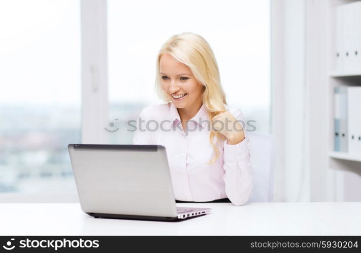 education, business and technology concept - smiling businesswoman or student with laptop computer in office