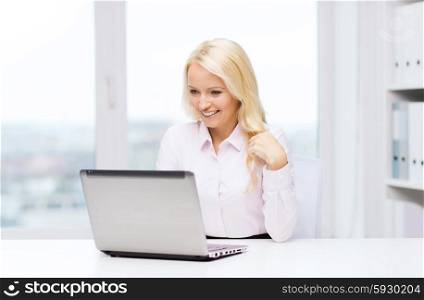 education, business and technology concept - smiling businesswoman or student with laptop computer in office
