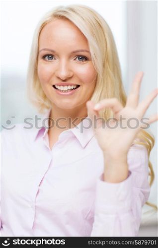 education, business, gesture, success and people concept - smiling businesswoman showing ok sign in office