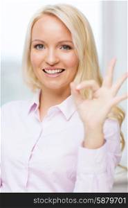education, business, gesture, success and people concept - smiling businesswoman showing ok sign in office