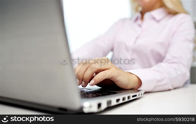 education, business, people and technology concept - close up of smiling woman hands or student with laptop computer typing in office