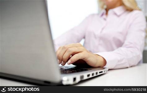 education, business, people and technology concept - close up of smiling woman hands or student with laptop computer typing in office