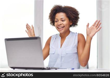 education, business, success and technology concept - happy african american businesswoman or student with laptop computer and papers at office
