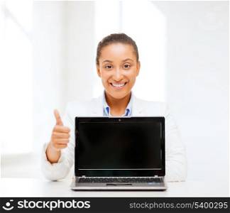 education,business, technology and internet concept - smiling woman with laptop computer