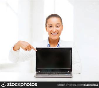 education,business, technology and internet concept - smiling woman with laptop computer