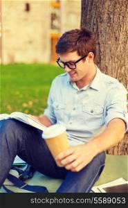 education, campus and people concept - smiling teenager in eyeglasses reading book with take away coffee