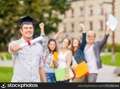 education, campus and teenage concept - smiling teenage boy in corner-cap with diploma and classmates on the back