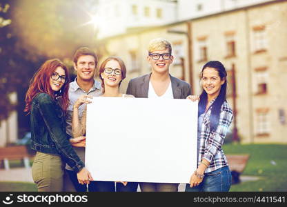 education, campus, friendship and people concept - group of happy teenage students holding big white blank billboard