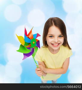 education, childhood and ecology concept - smiling child with colorful windmill toy