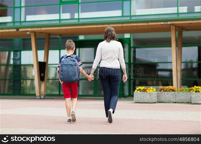 education, childhood, family and people concept - elementary student boy with mother going to school
