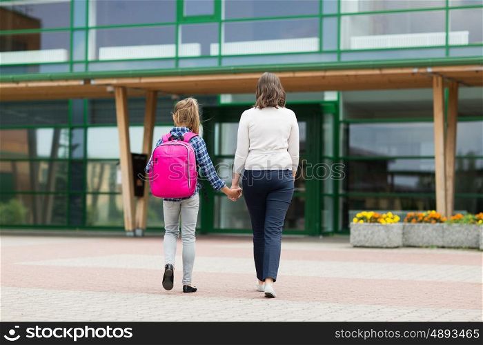education, childhood, family and people concept - elementary student girl with mother going to school