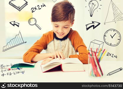 education, childhood, people, homework and school concept - happy student boy reading book or textbook at home over mathematical doodles. smiling, student boy reading book at home