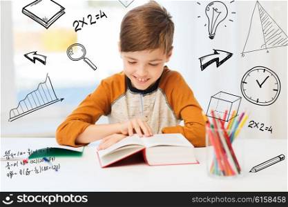 education, childhood, people, homework and school concept - happy student boy reading book or textbook at home over mathematical doodles