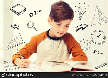 education, childhood, people, homework and school concept - student boy with book writing to notebook at home over mathematical doodles. student boy with book writing to notebook at home. student boy with book writing to notebook at home