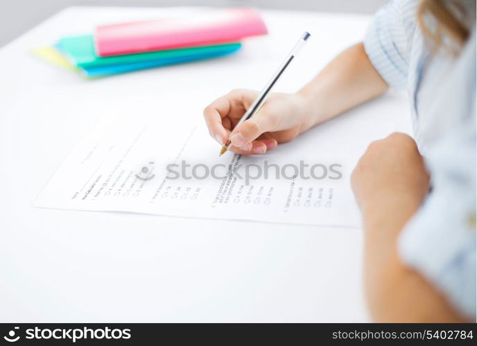 education, children and school concept - little student girl taking test