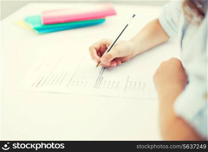 education, children and school concept - little student girl taking test