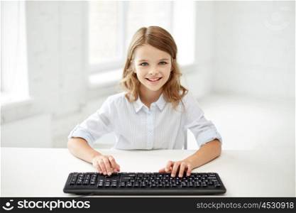 education, children, technology and people concept - little student girl with computer keyboard at school