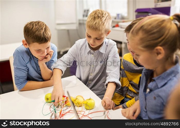 education, children, technology, science and people concept - group of happy kids playing with invention kit at robotics school lesson