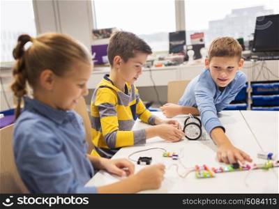 education, children, technology, science and people concept - group of happy kids building robots at robotics school lesson. happy children building robots at robotics school. happy children building robots at robotics school