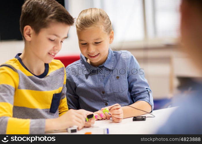 education, children, technology, science and people concept - happy kids building robots at robotics school lesson