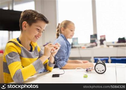 education, children, technology, science and people concept - happy kids building robots at robotics school lesson. happy children building robots at robotics school. happy children building robots at robotics school