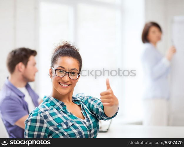 education concept - african student girl showing thumbs up at school