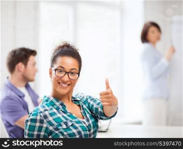 education concept - african student girl showing thumbs up at school