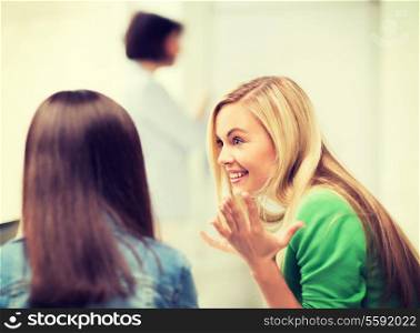 education concept - attractive student girl gossiping in lecture at school