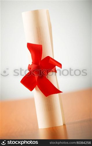 Education concept - diploma roll on the wooden table
