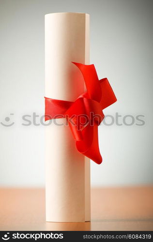 Education concept - diploma roll on the wooden table