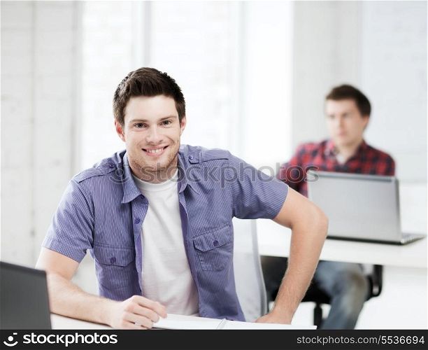 education concept - group of smiling students with laptops at school