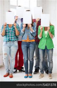 education concept - group of students covering faces with blank papers