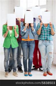 education concept - group of students covering faces with blank papers