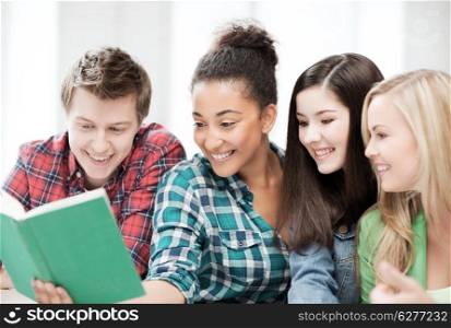 education concept - group of students reading book at school