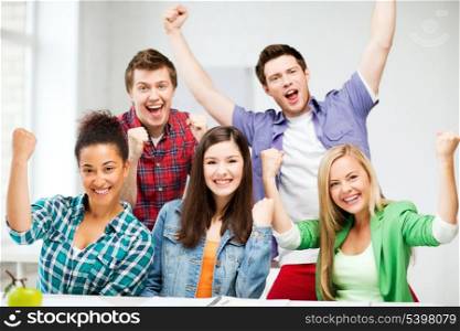 education concept - happy team of students holding hands up at school